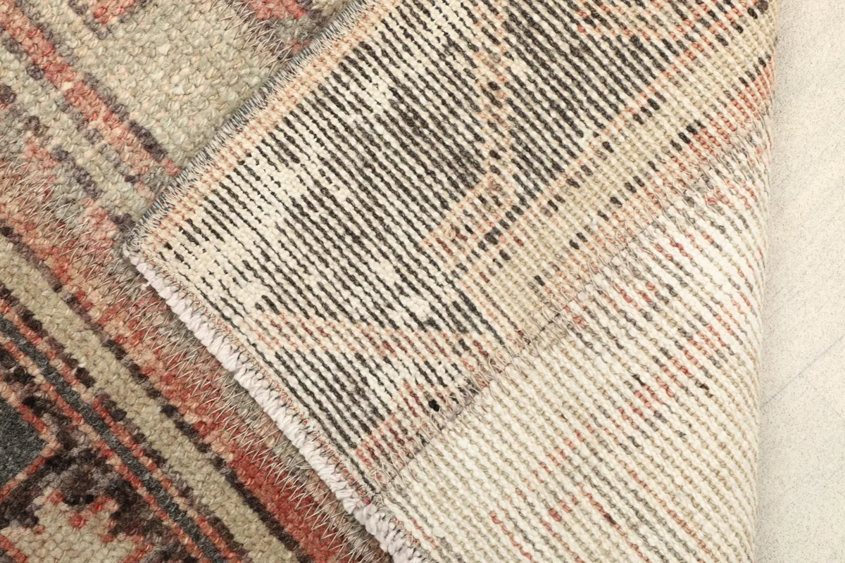 Close-up of the rug's back, revealing the intricate hand-knotting and cotton foundation.
