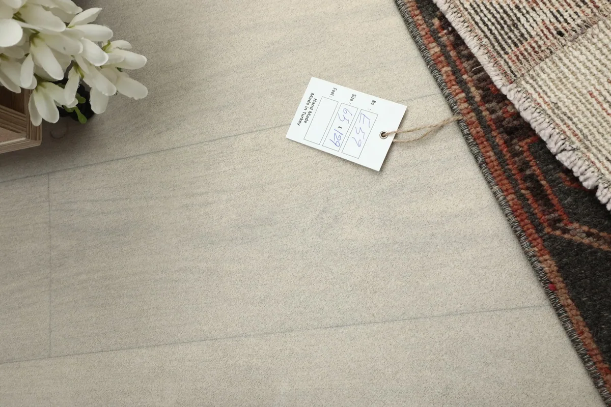 A partial view of the rug next to a product tag, emphasizing its unique character.