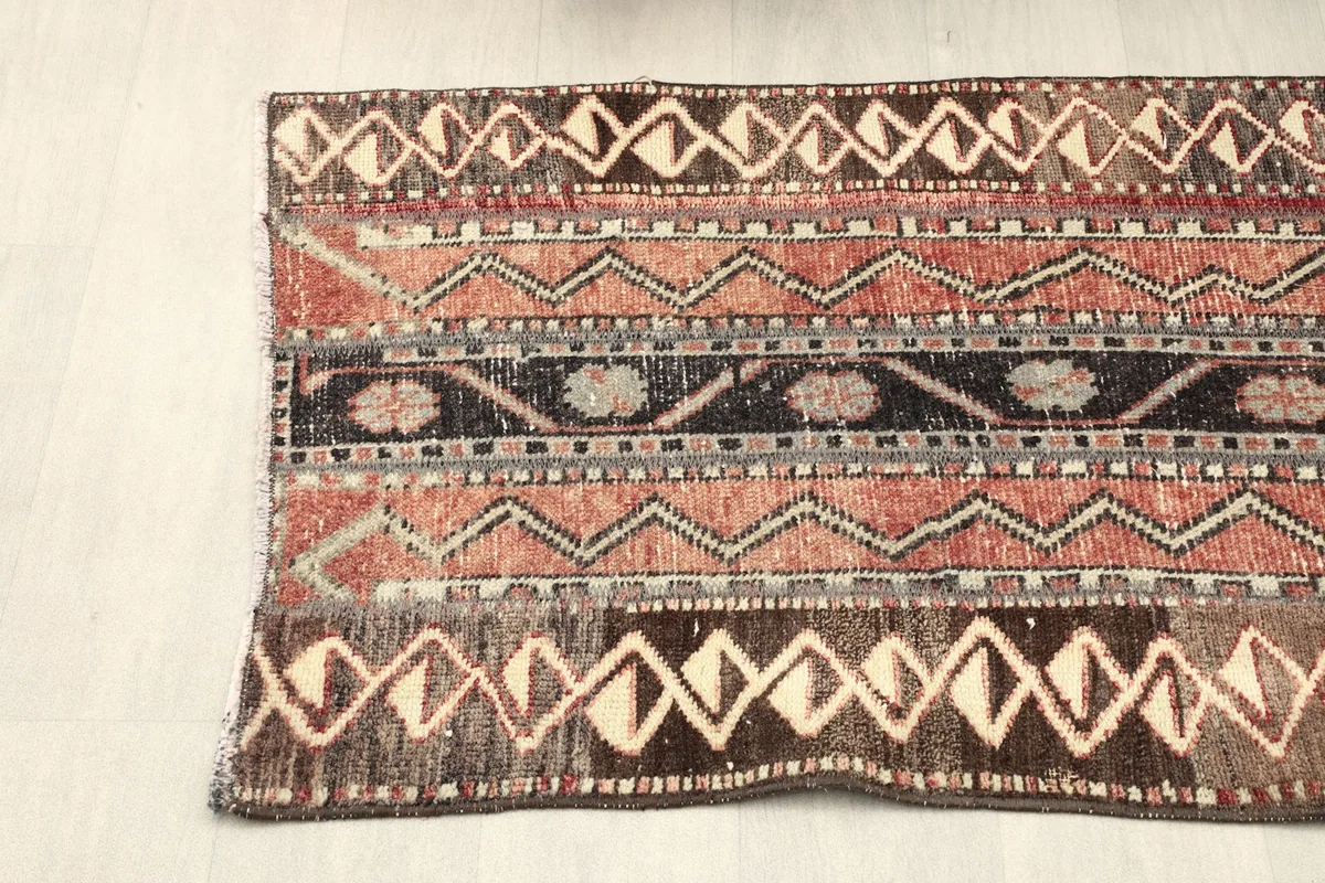 Overhead view of one half of the rug, displaying the repeated geometric and tribal band designs.