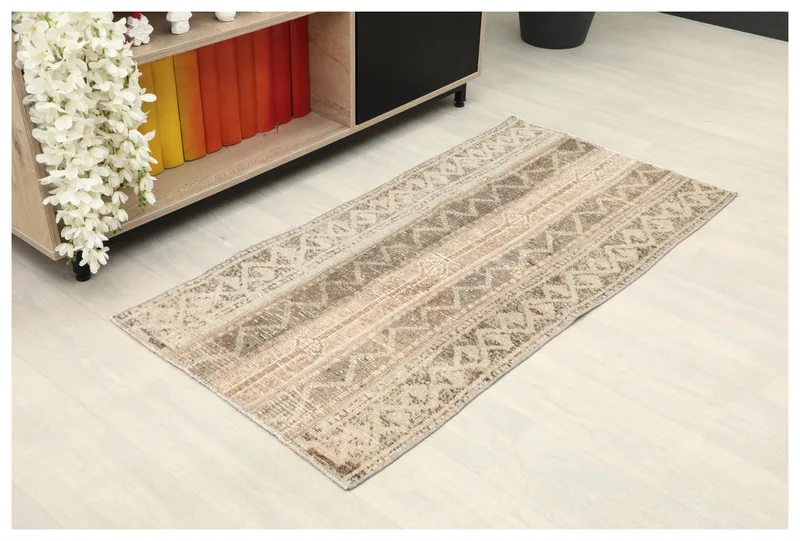 Full overhead view of the beige and brown striped geometric vintage rug on a white background.