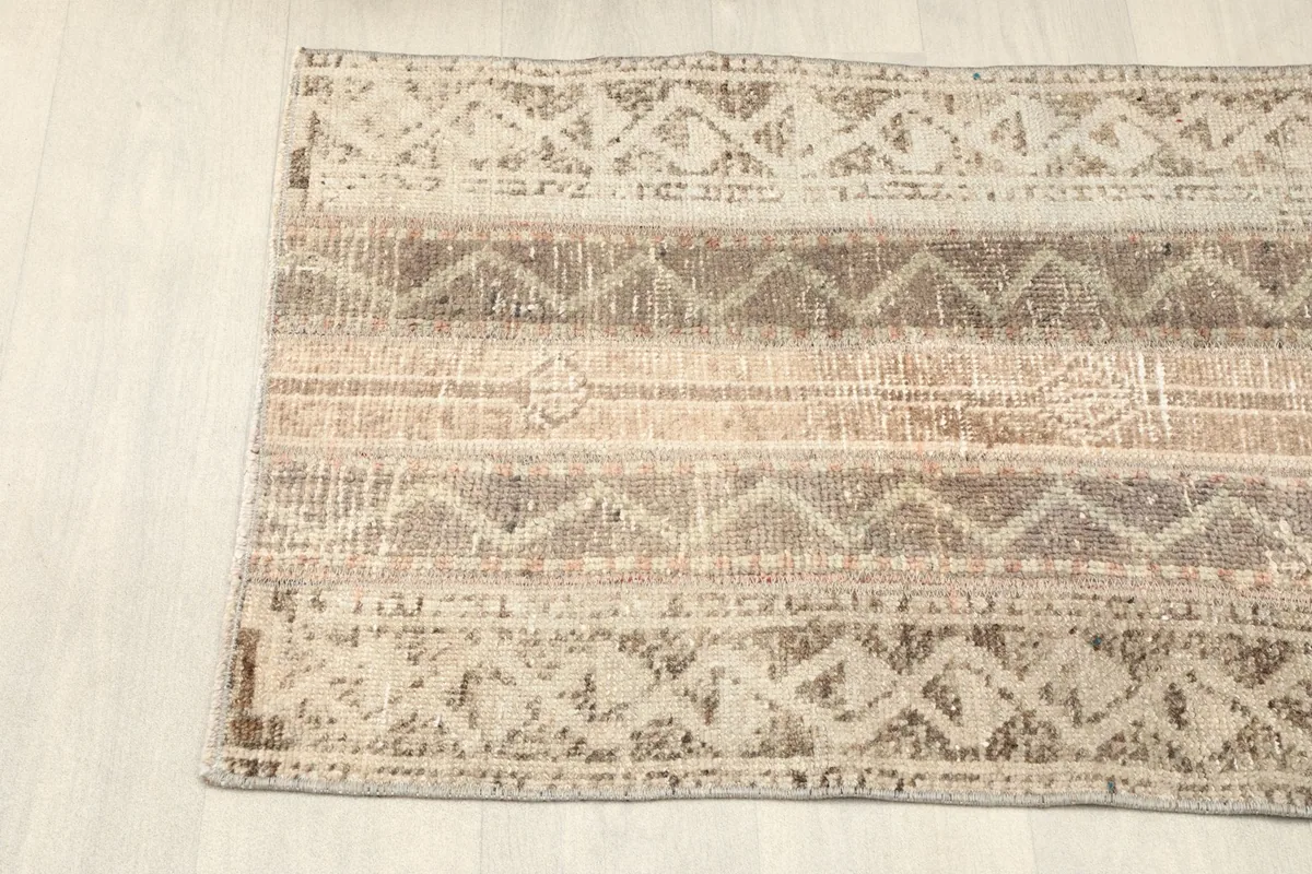 Angled view of one end of the rug, showcasing the striped design and natural wear.