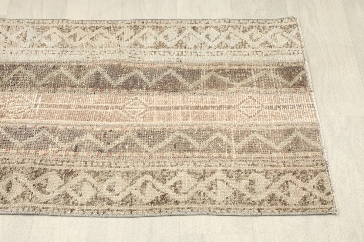 Angled view of the opposite end of the rug, showing consistency in pattern and patina.
