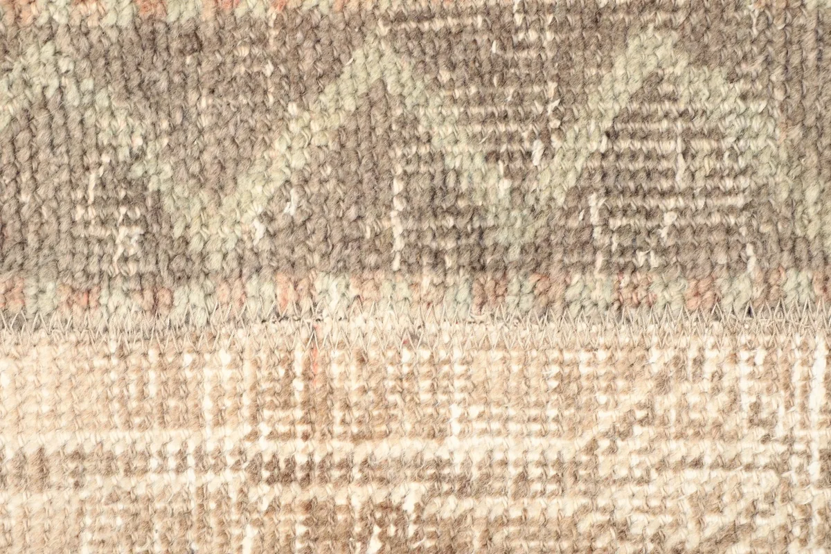 Detailed view of the rug's low wool pile and the intricate weaving of the geometric motifs.