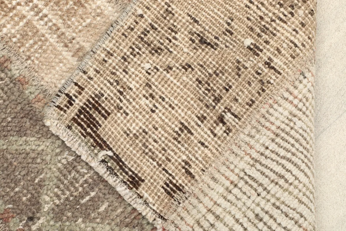 Close-up of the rug's back, revealing the hand-knotted construction and cotton foundation.