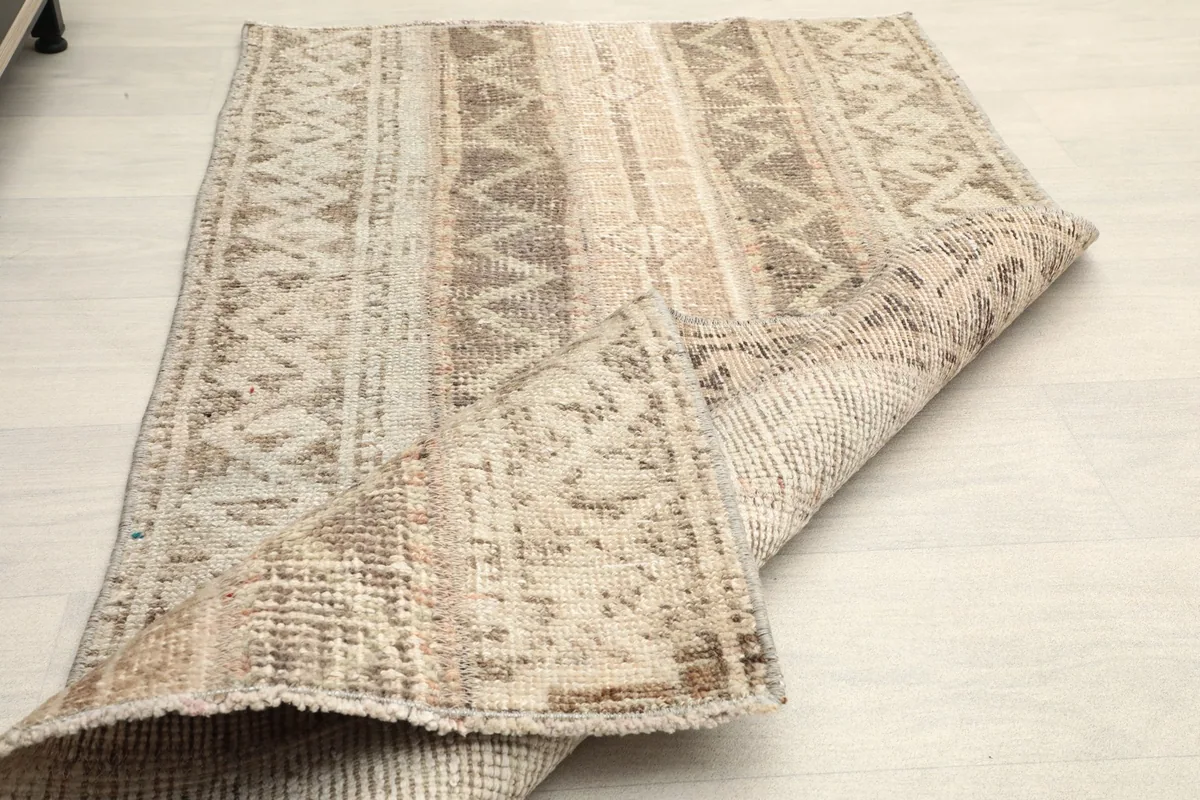 The rug folded back, displaying its flexibility and the reverse side.