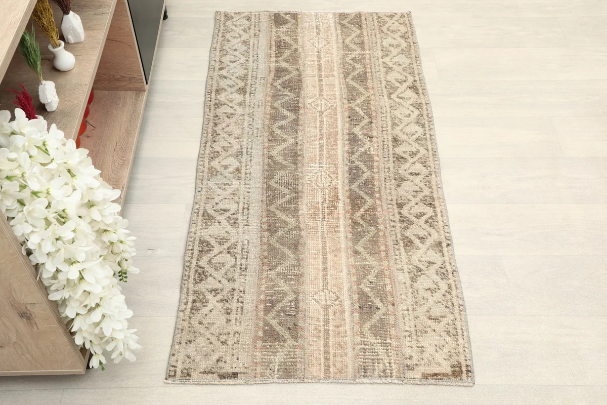 Overhead view of the vintage area rug, highlighting its striped geometric design and muted colors.
