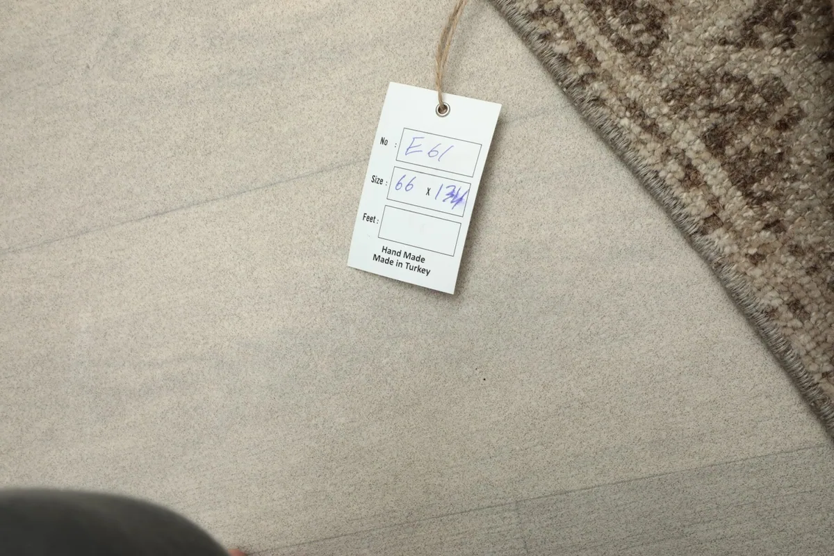 Product tag attached to the rug, indicating its origin from Turkey and hand-knotted quality.