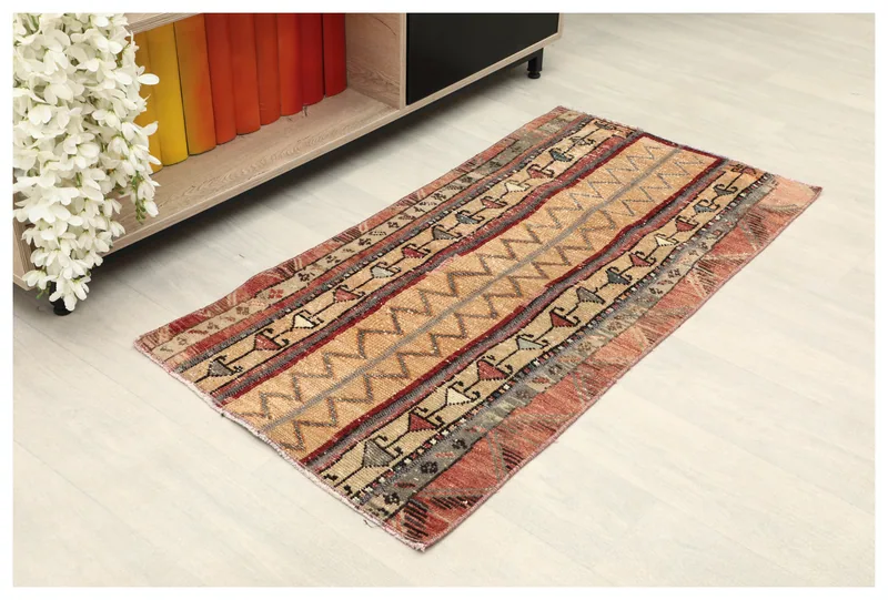 Full top view of the beige and red striped geometric vintage Anatolian rug on a white background.