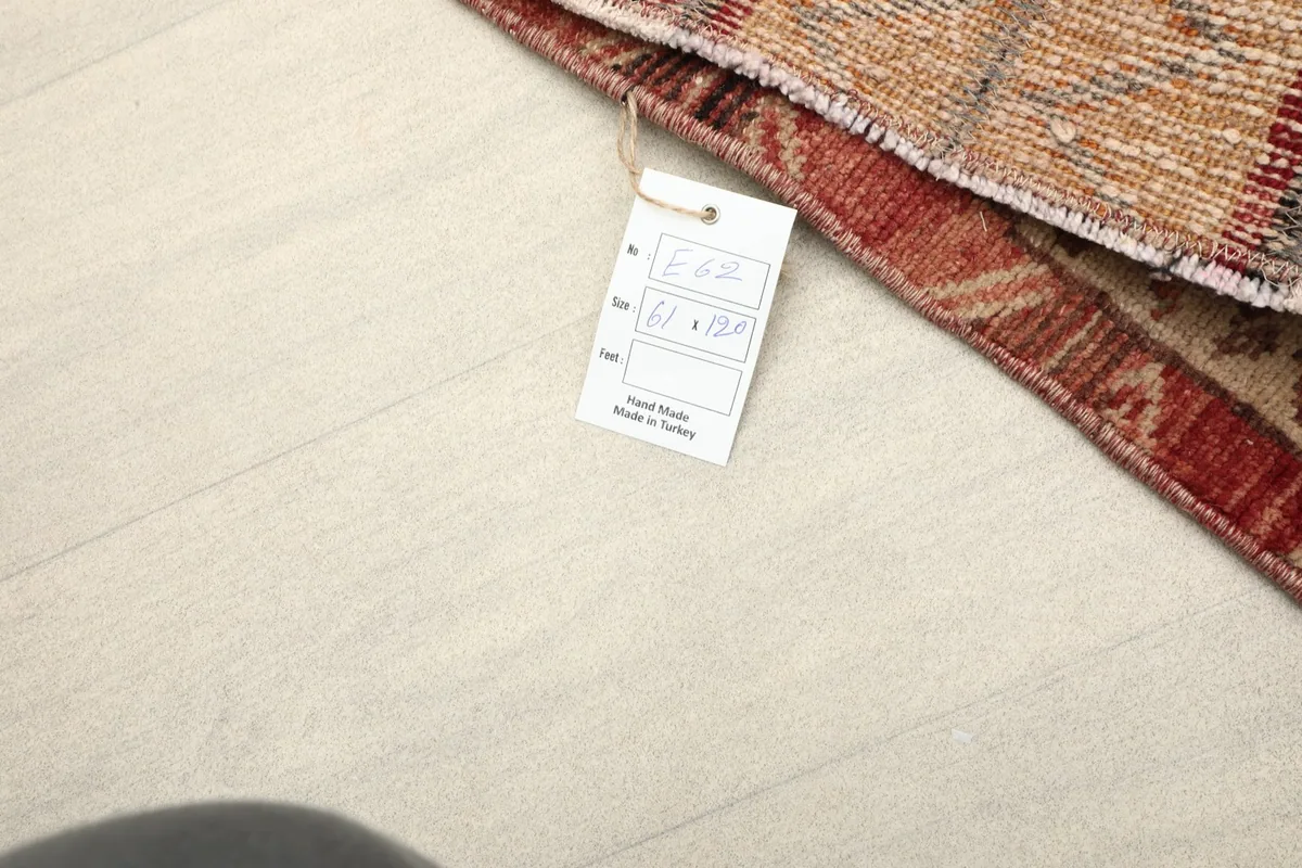 Close-up of the rug's tag, displaying the size 61 x 120 cm and origin 'Hand Made in Turkey'.