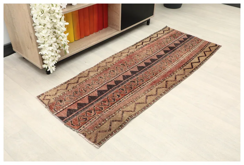 Full top view of the 2'0" x 5'3" rust and beige tribal runner rug on a white background.