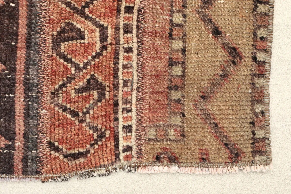 Close-up detail of the rug's edge, showing the hand-knotted wool pile and cotton foundation.