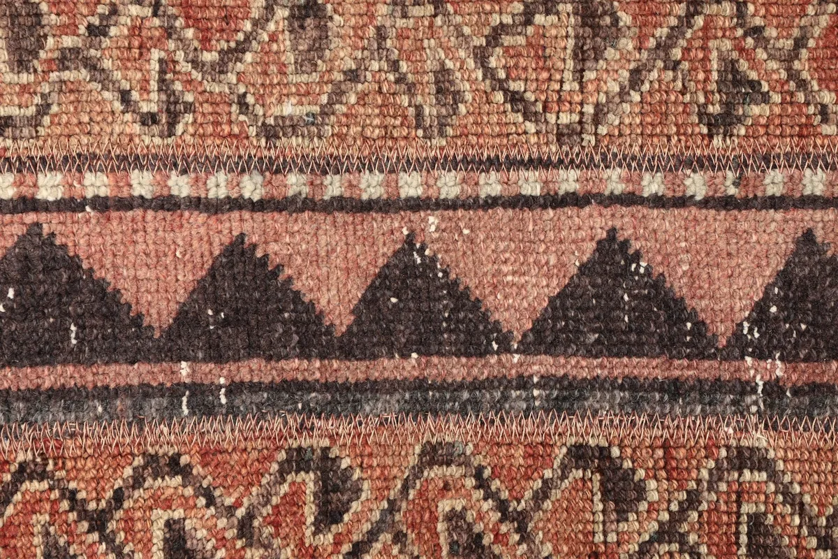 Detailed view of the rug's central design, featuring black triangles and intricate patterns.