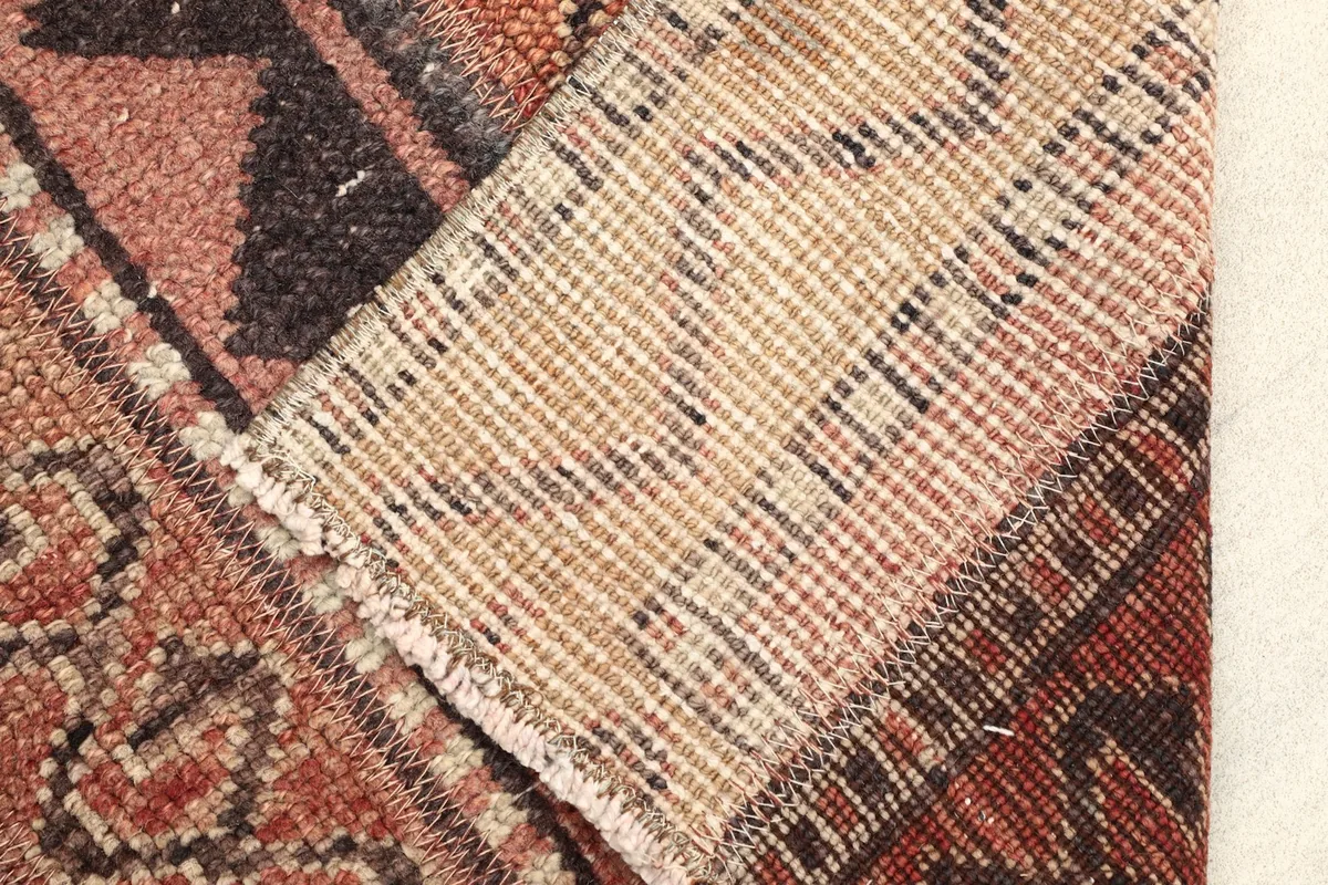 View of the back of the rug, revealing the tightly hand-knotted wool construction on cotton.