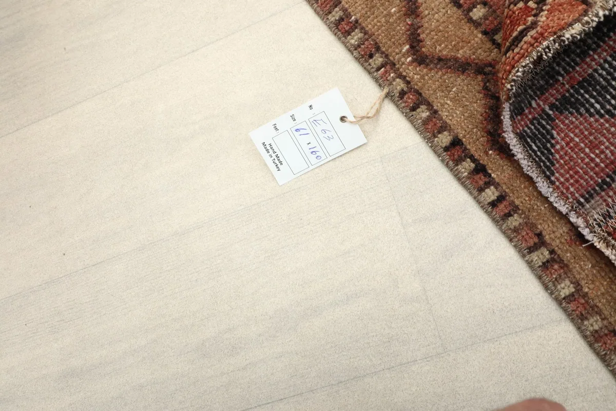 A small tag on the floor next to the rug, showing its dimensions and origin.