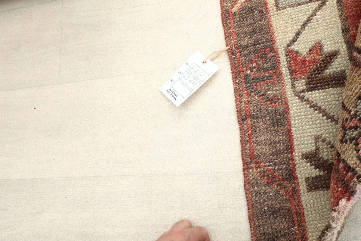 Corner of the rug with a tag, showing the reverse side and the hand-finished edges.