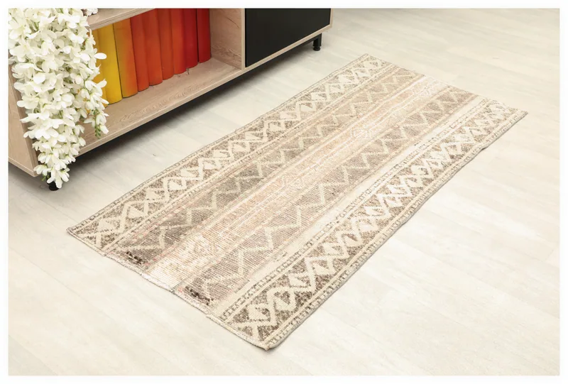 Full top view of the 2x5 vintage Anatolian rug with beige, cream, brown, and gray geometric patterns