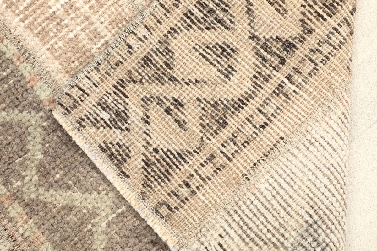 View of the rug's cotton foundation and the reverse side of the hand-knotted wool pile