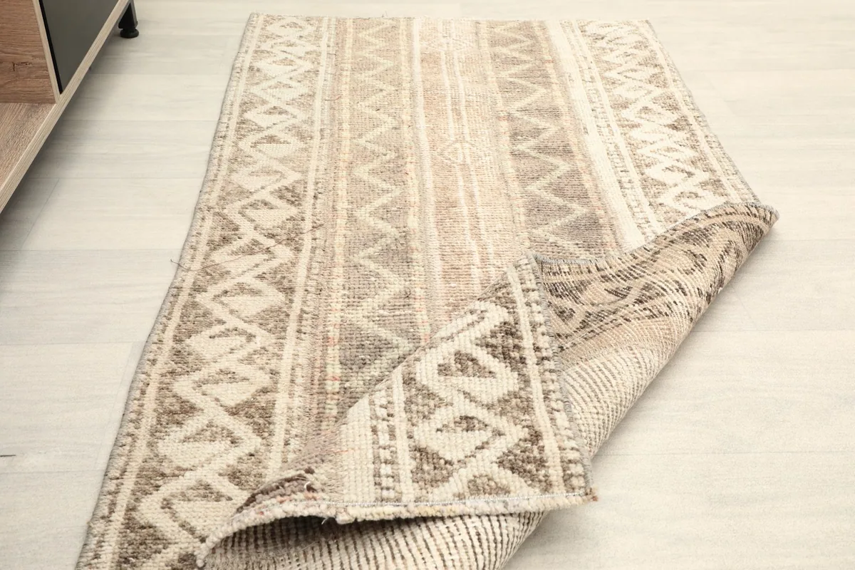 Rug partially folded to illustrate its flexibility and the quality of the wool and cotton materials