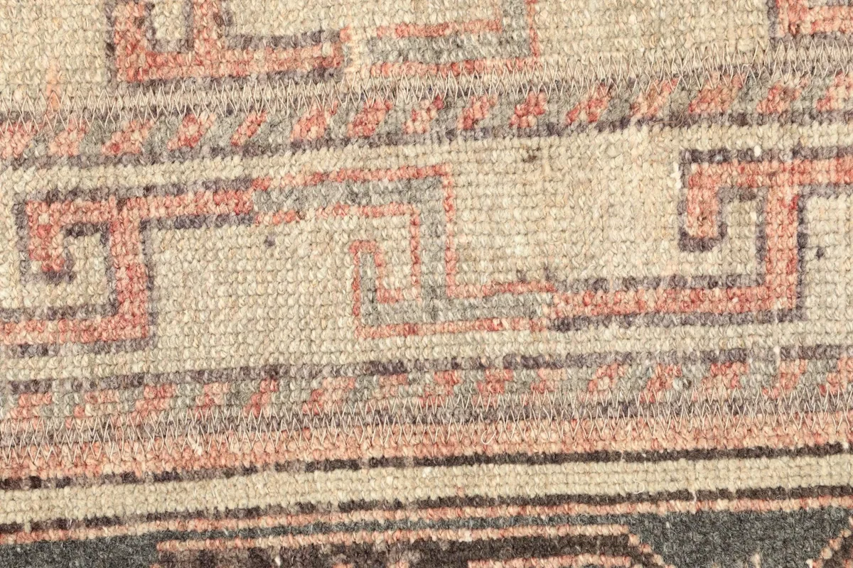 Detailed view of the central geometric patterns and their gentle, aged patina.