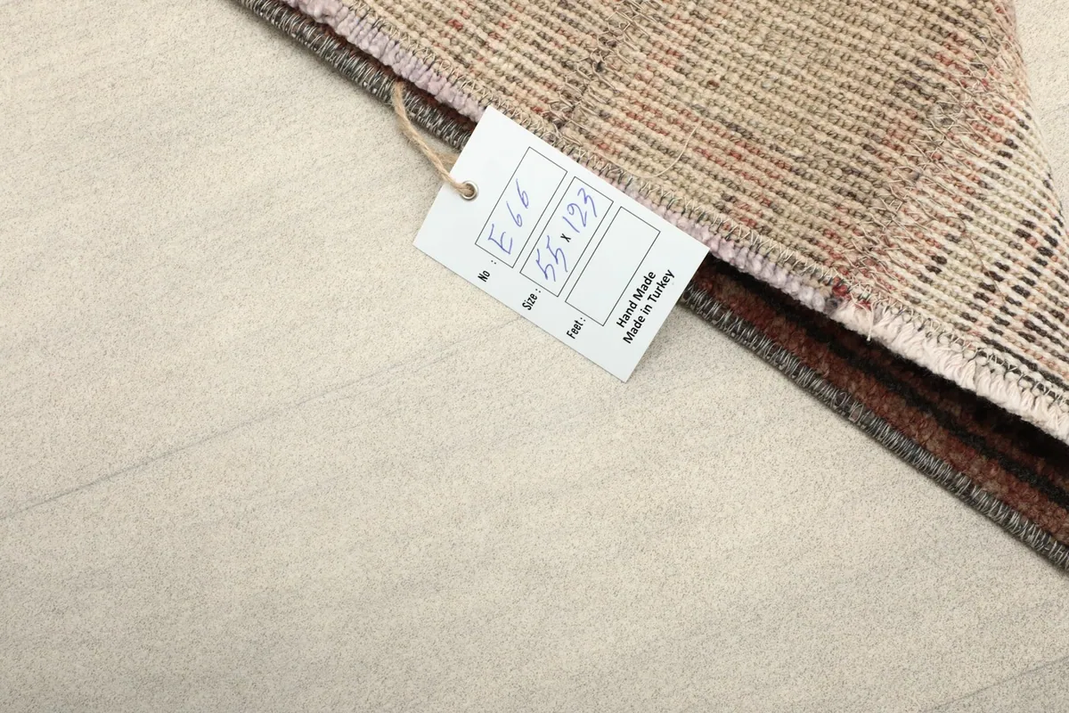 Close-up of the rug's label, indicating its hand-made origin in Turkey and size.