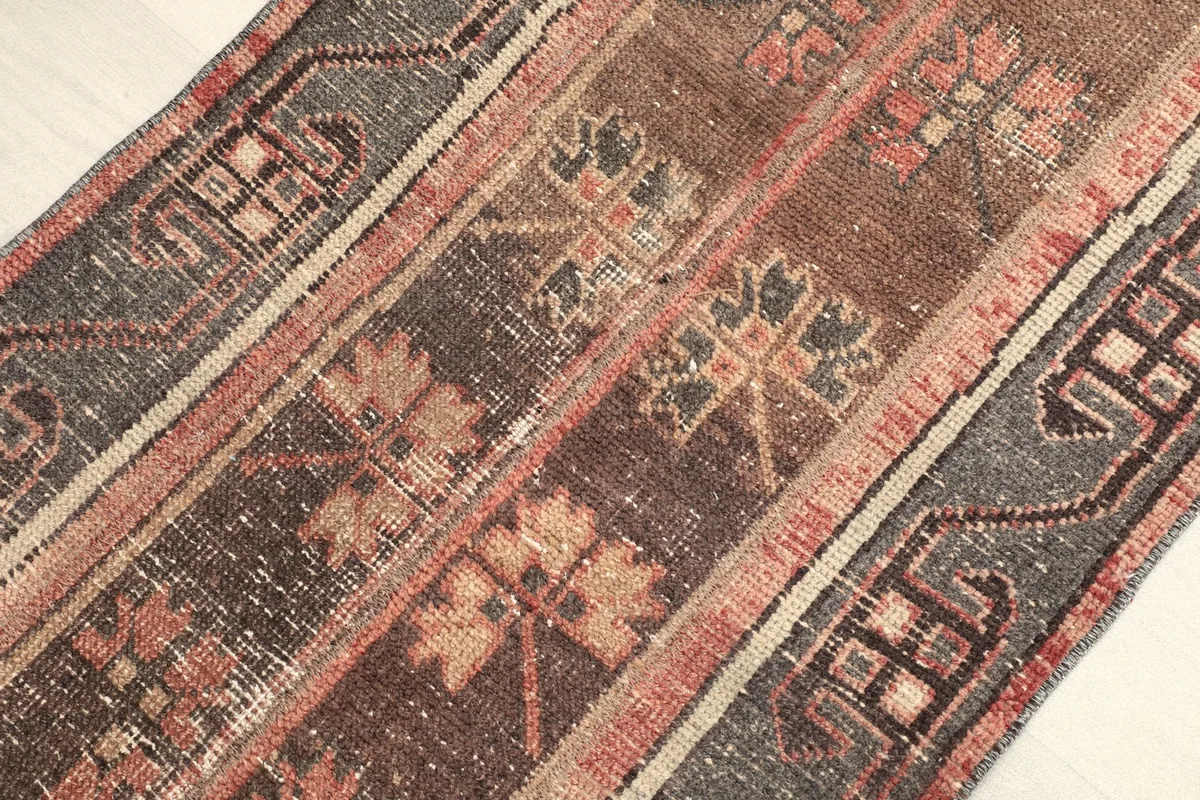 Angled view across the rug's surface, revealing the varied texture and low pile.