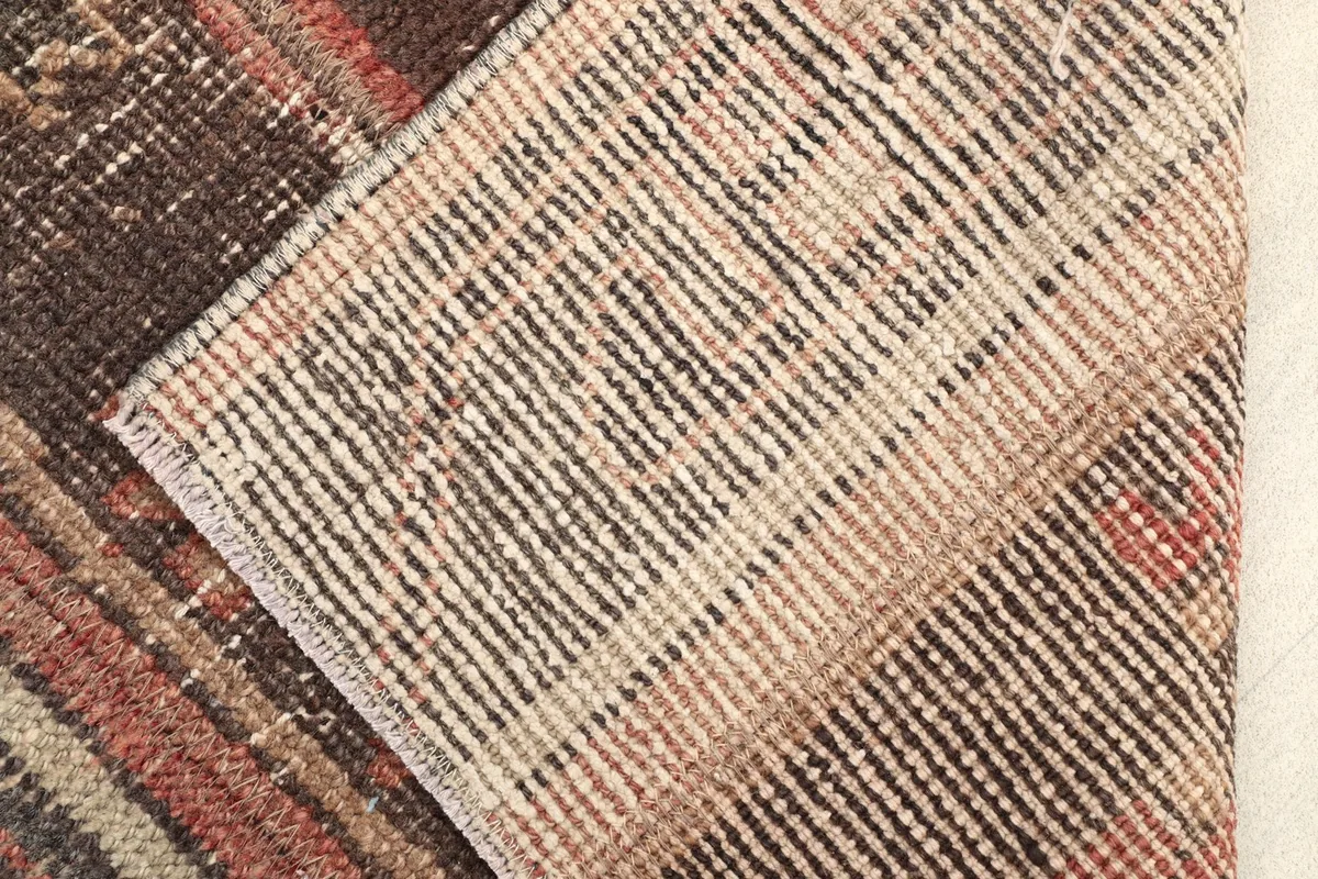 View of the rug's cotton foundation, showcasing the hand-knotted construction from the reverse side.