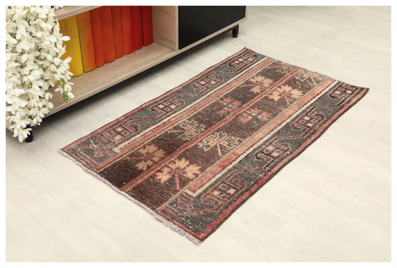 Full top view of a brown, gray, and rust vintage Anatolian rug on a white background.