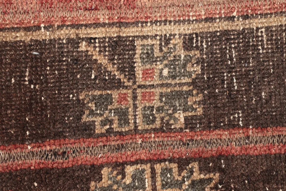 Detailed view of a geometric motif with red and gray accents within the rug's pattern.