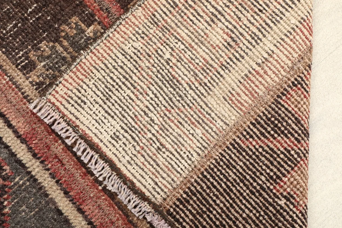 View of the back of the hand-knotted wool rug, showing the cotton foundation.