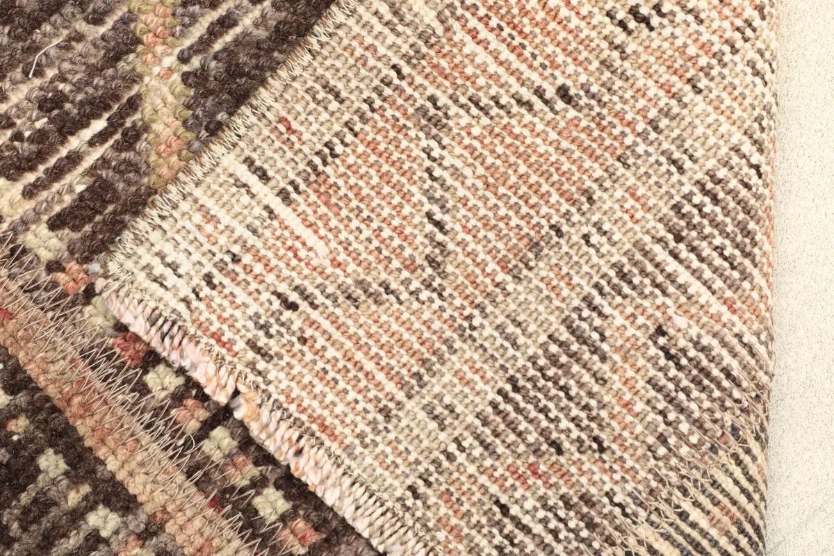 View of the back of the hand-knotted rug, showcasing the cotton foundation and tight weave.