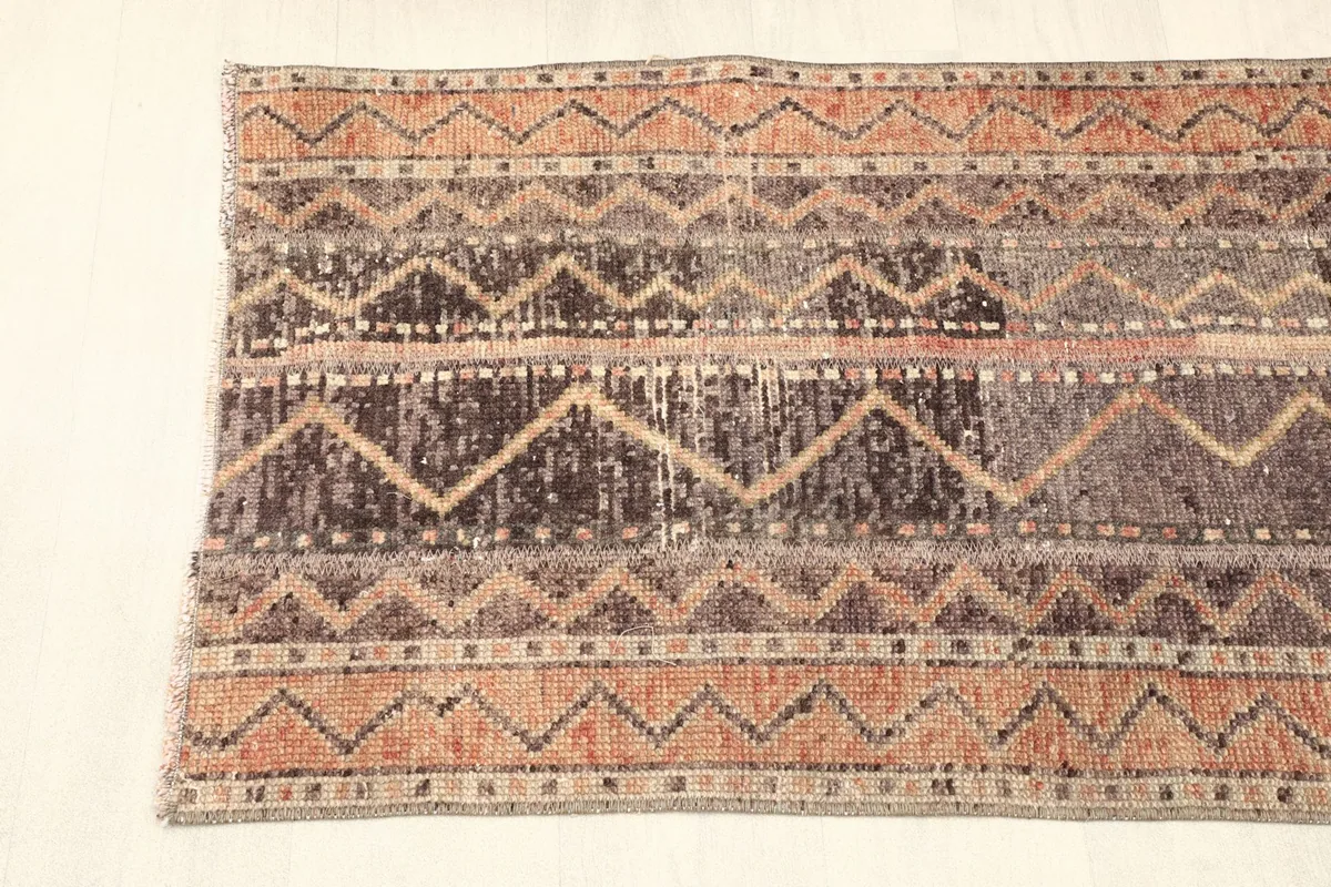 Partial overhead view showing the rug's width and the repeating zig-zag and stripe patterns.