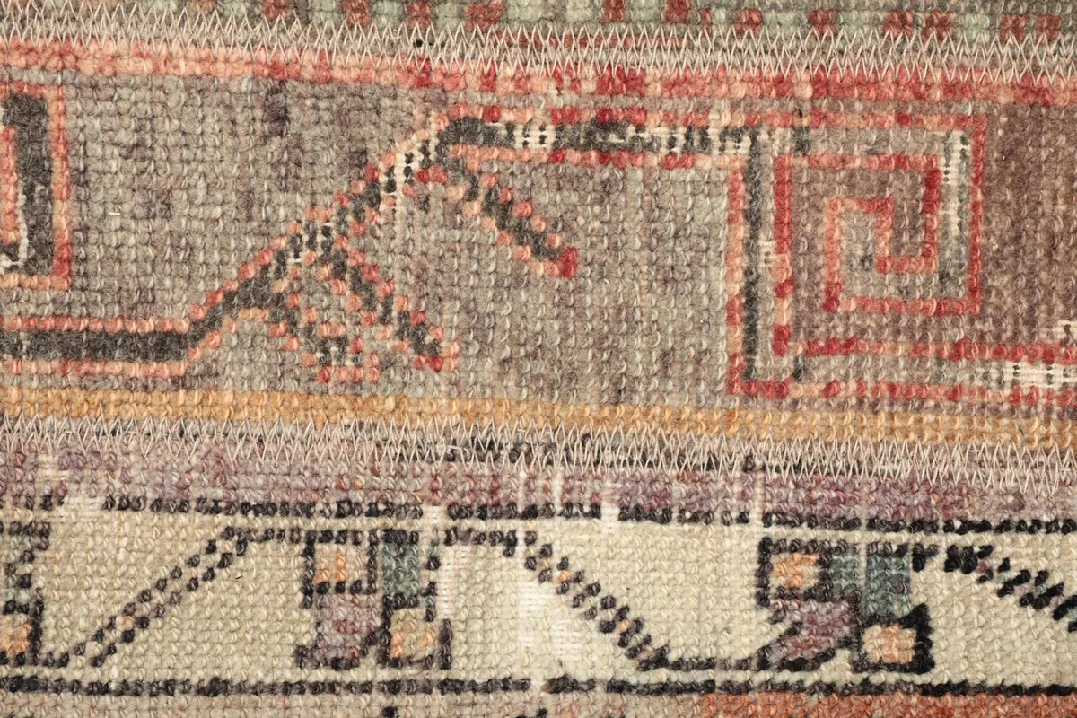Detailed view of the geometric and tribal motifs within the rust and gray sections.