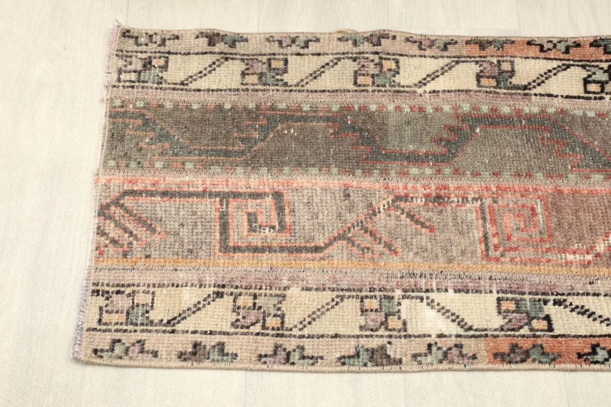 Close-up of one end of the runner, showing the beige border with black and rust patterns.