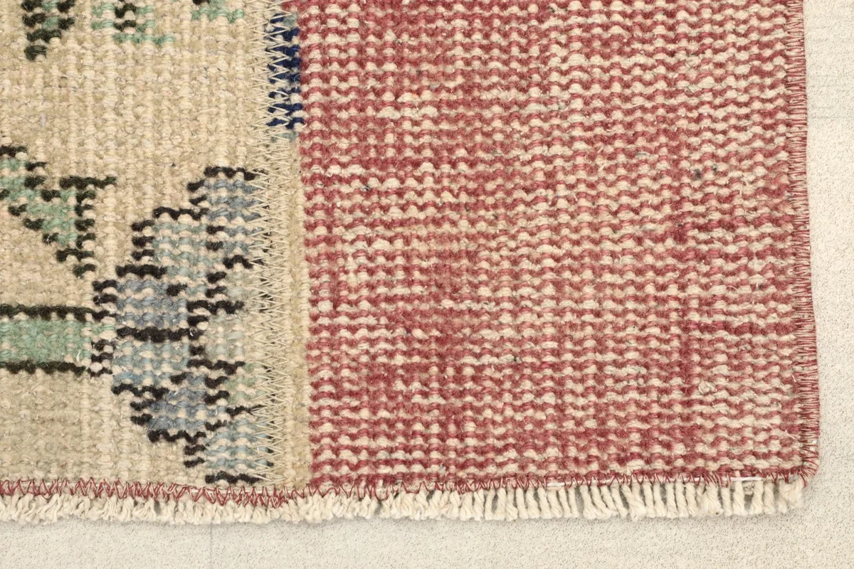 Close-up detail showing the rose pile next to the beige center with blue and green motifs