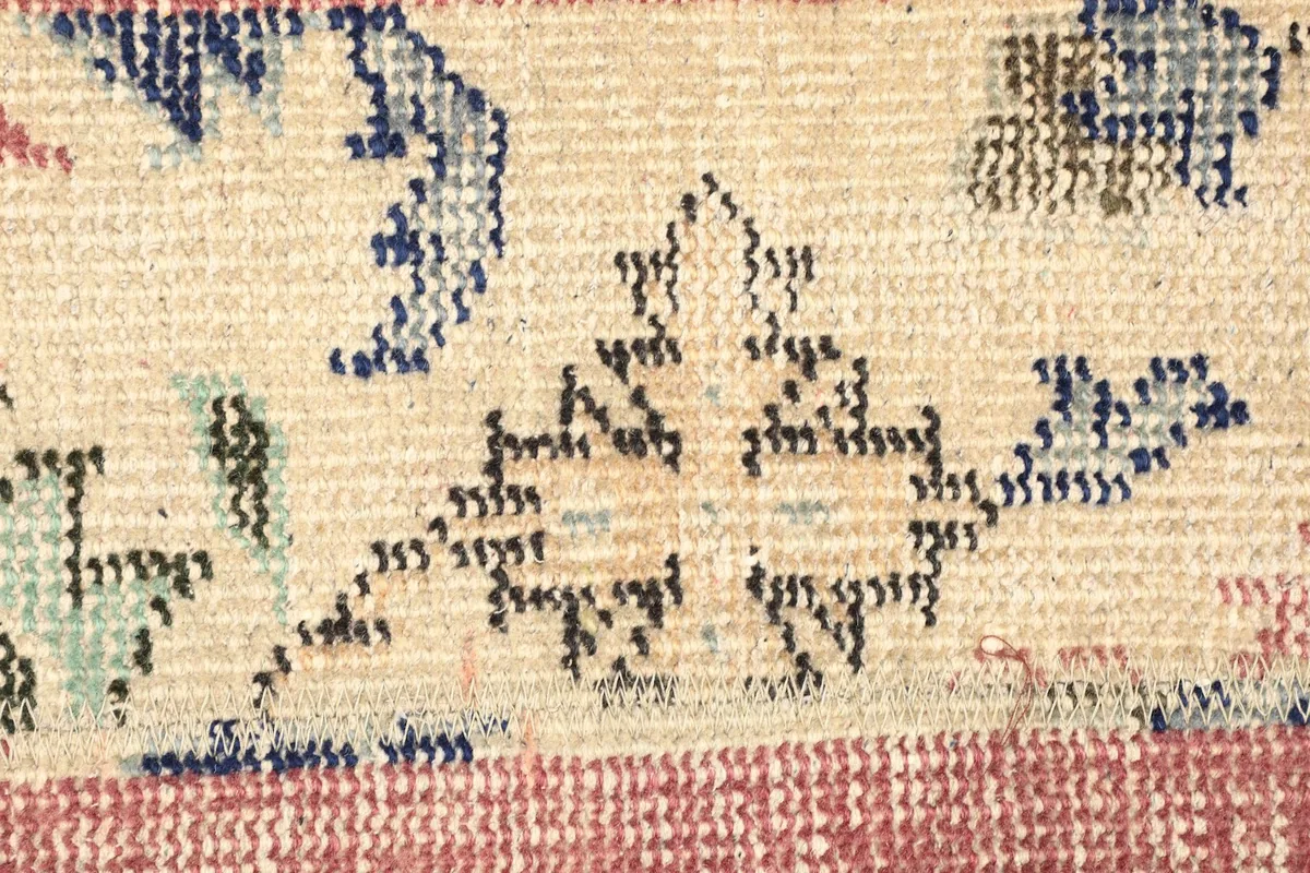 Macro detail of the hand-knotted wool pile and the subtle floral and geometric motifs
