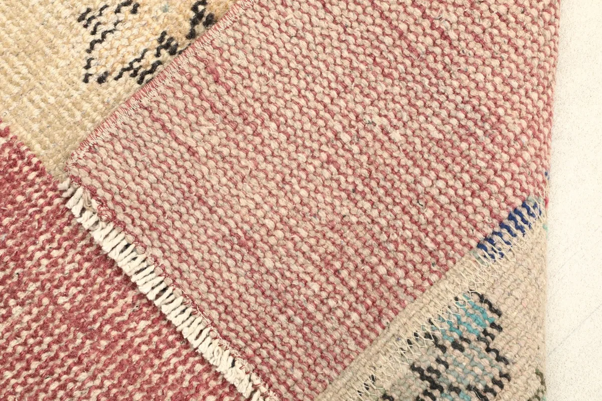 View of the back of the rug, revealing the tightly woven cotton foundation and wool knots