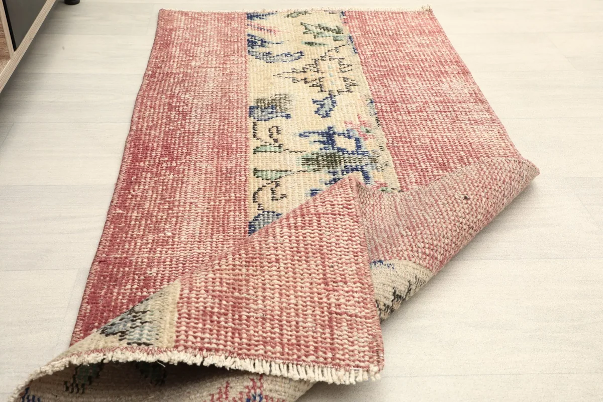 The rug folded to show the thickness and the flexibility of the vintage wool on cotton construction