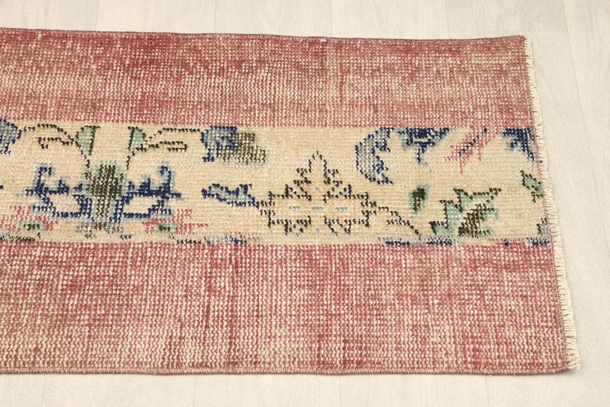 Overhead view of the other end of the rug, displaying the consistent rose and beige design