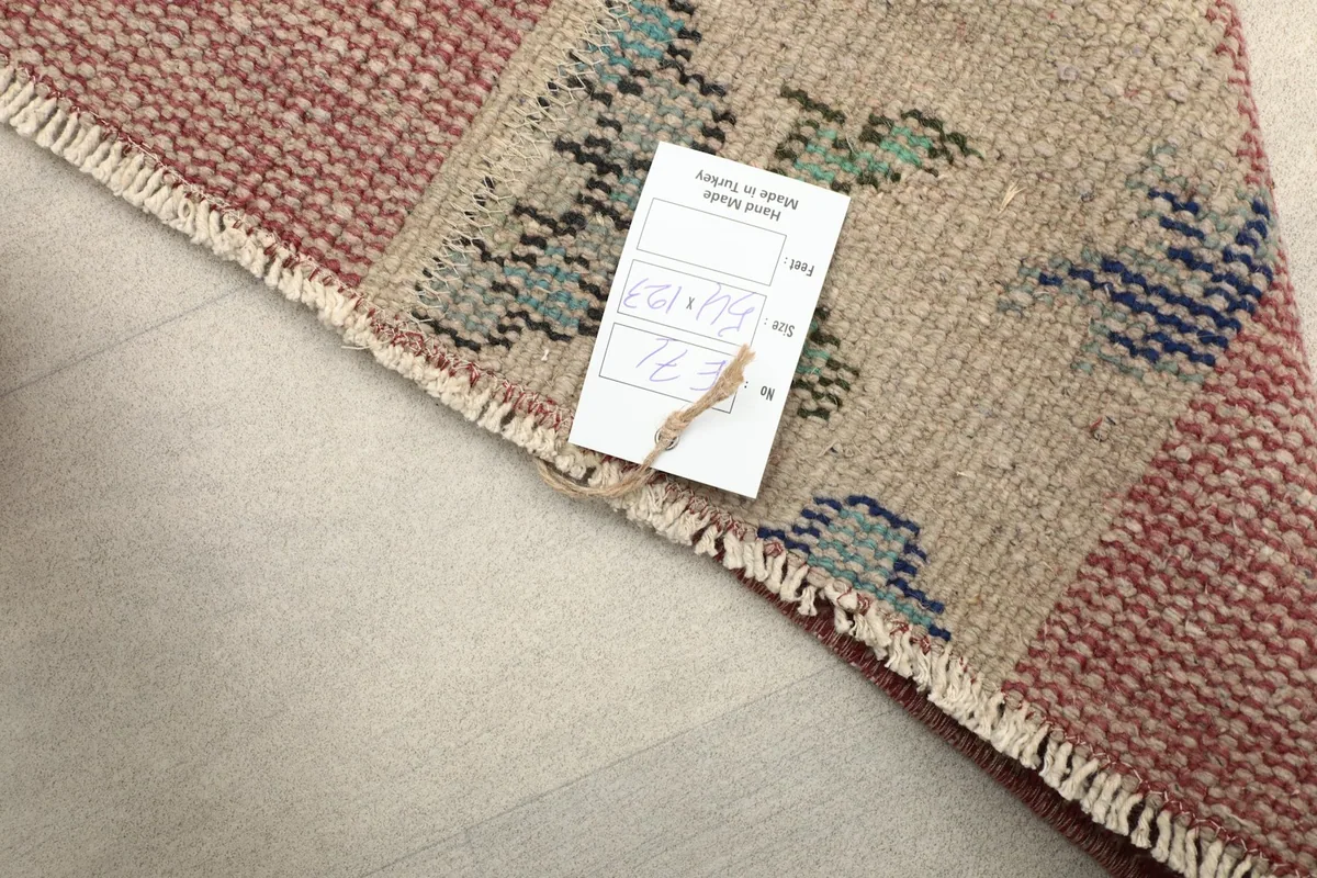 Close-up of the rug's label attached to the fringe, showing authenticity details