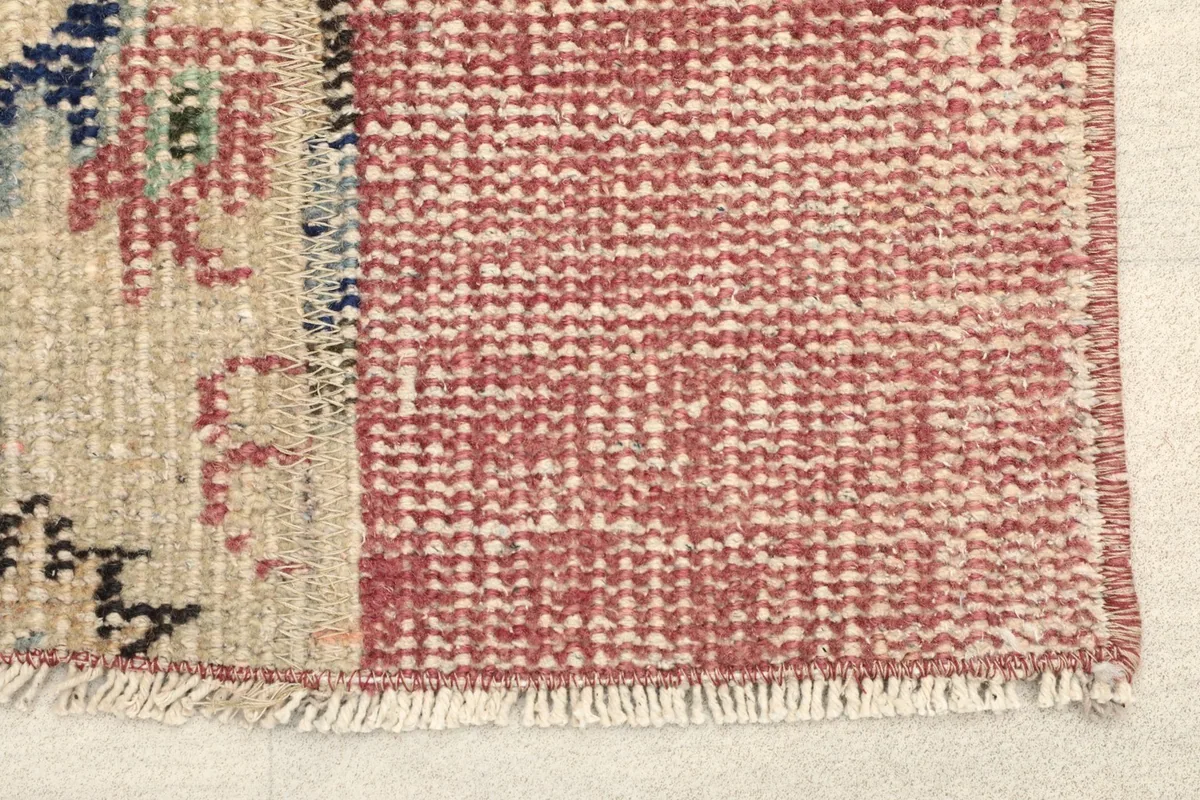 Close-up detail of the rose patchwork texture and the edge of the beige central panel.