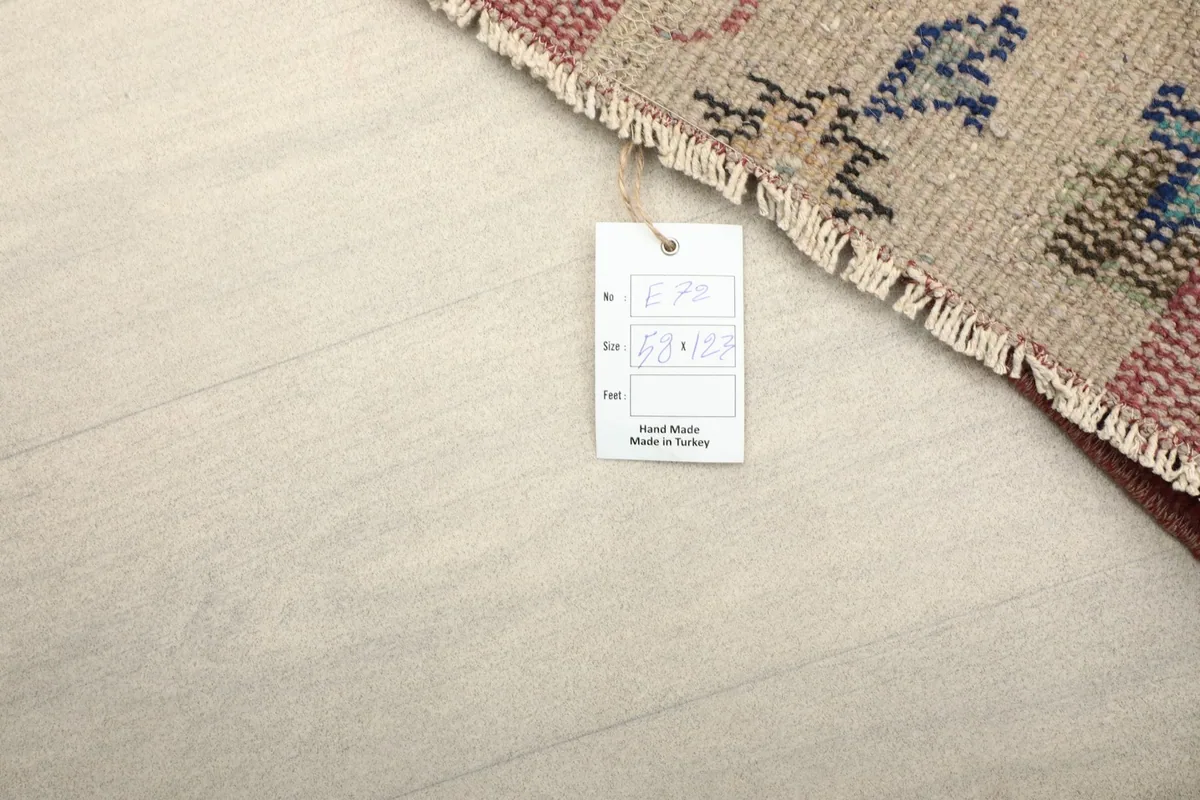 Reverse side of the rug with a tag, showing the cotton foundation and hand-knotted construction.