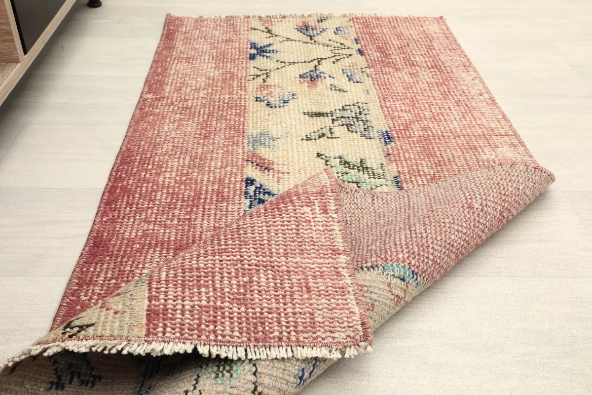 The rug folded to show the flexibility and thickness of the vintage wool material.