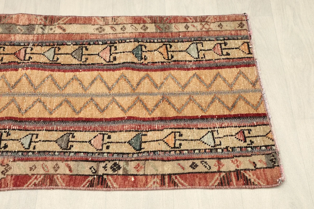 Angled view from the opposite end, capturing the color fade and tribal elements in the stripes.