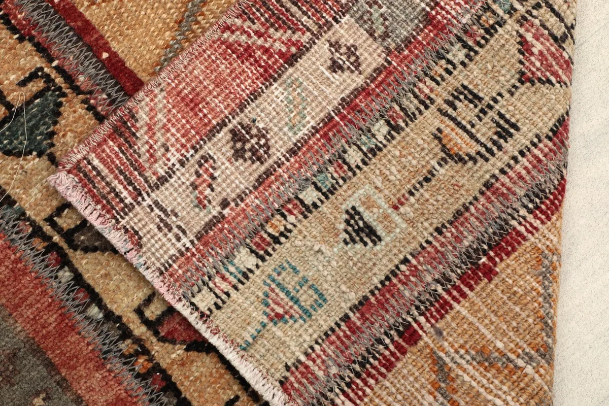Close-up of the back of the rug, revealing the hand-knotted cotton foundation and wool pile.