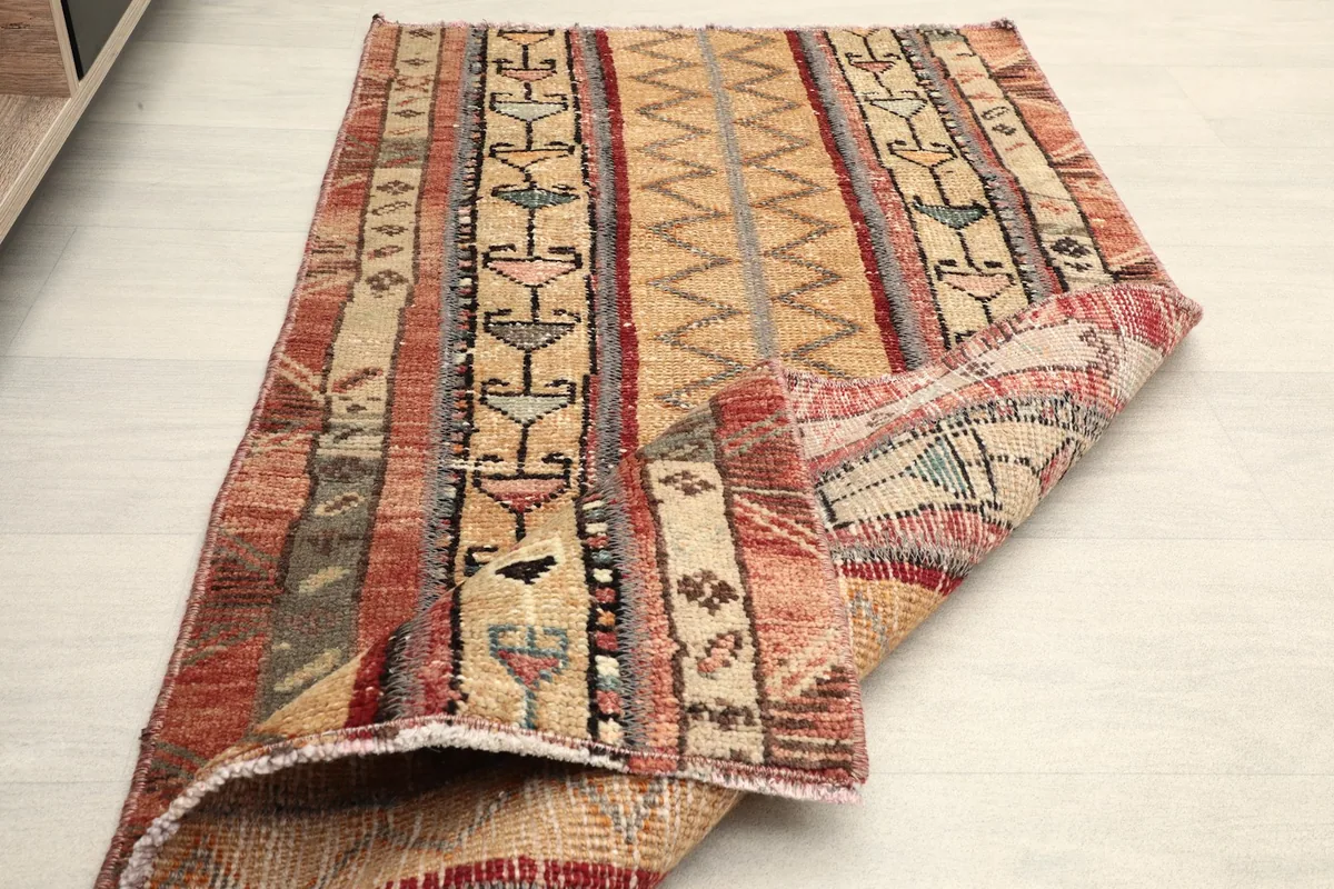 Rug partially folded, displaying the thickness and flexibility of the vintage hand-knotted construction.