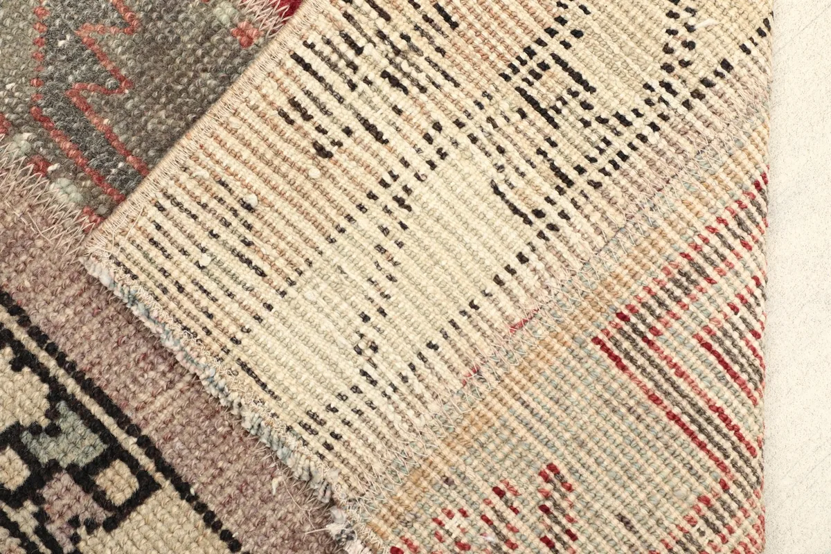 View of the back of the hand-knotted rug, revealing the cotton foundation and knotting structure.