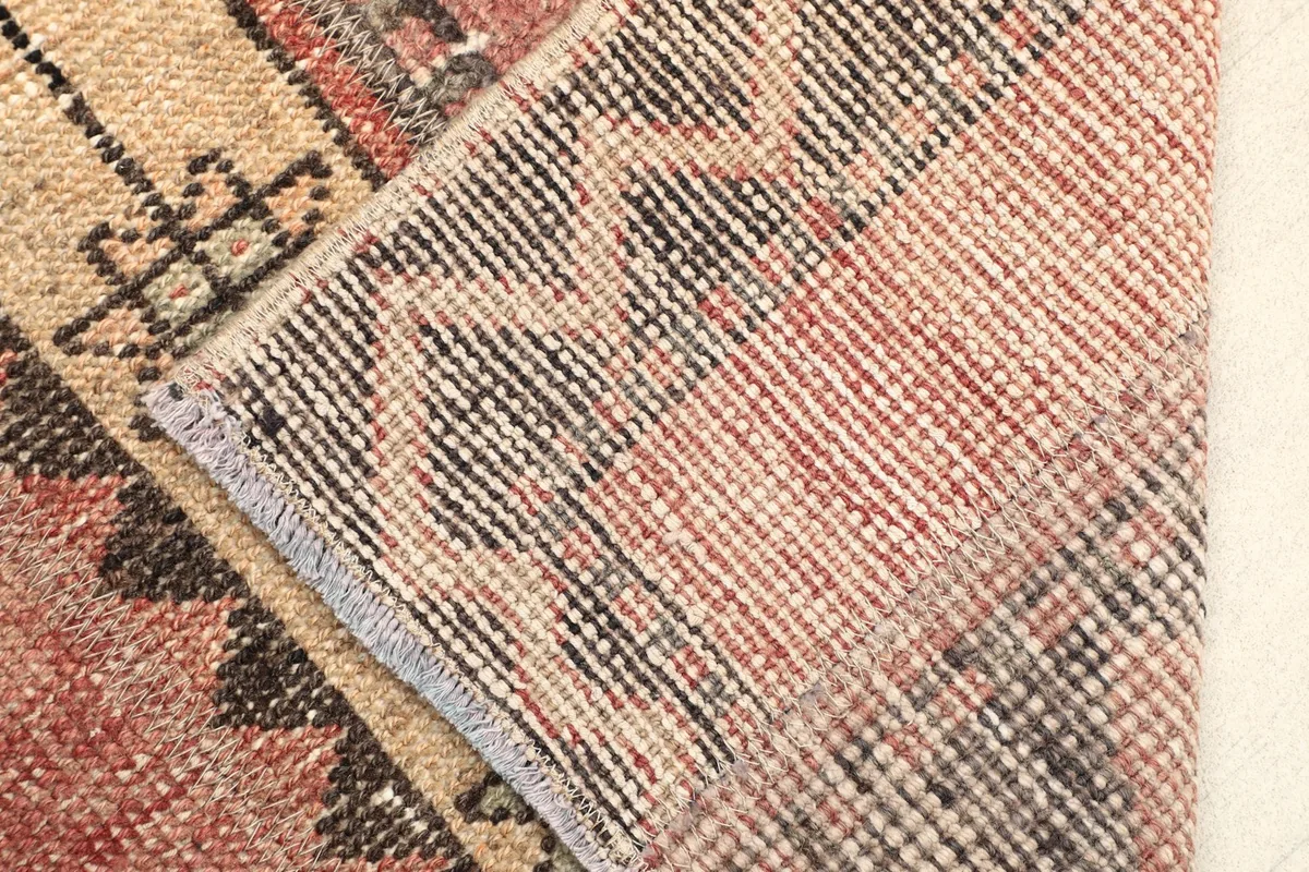 Close-up view of the back of the rug, revealing the hand-knotted wool on cotton foundation.