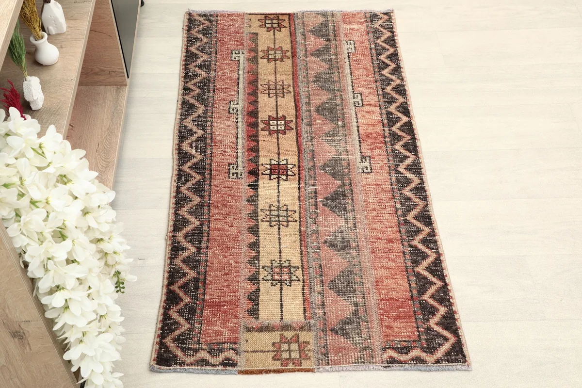 Straight overhead view of the vintage Anatolian rug, highlighting its rose, beige, and charcoal geometric patterns.