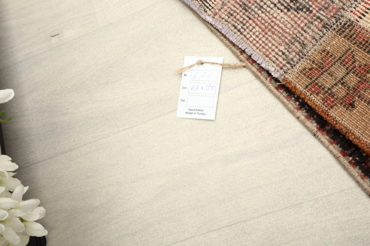 Close-up of the product tag attached to the rug, indicating it is handmade in Turkey.