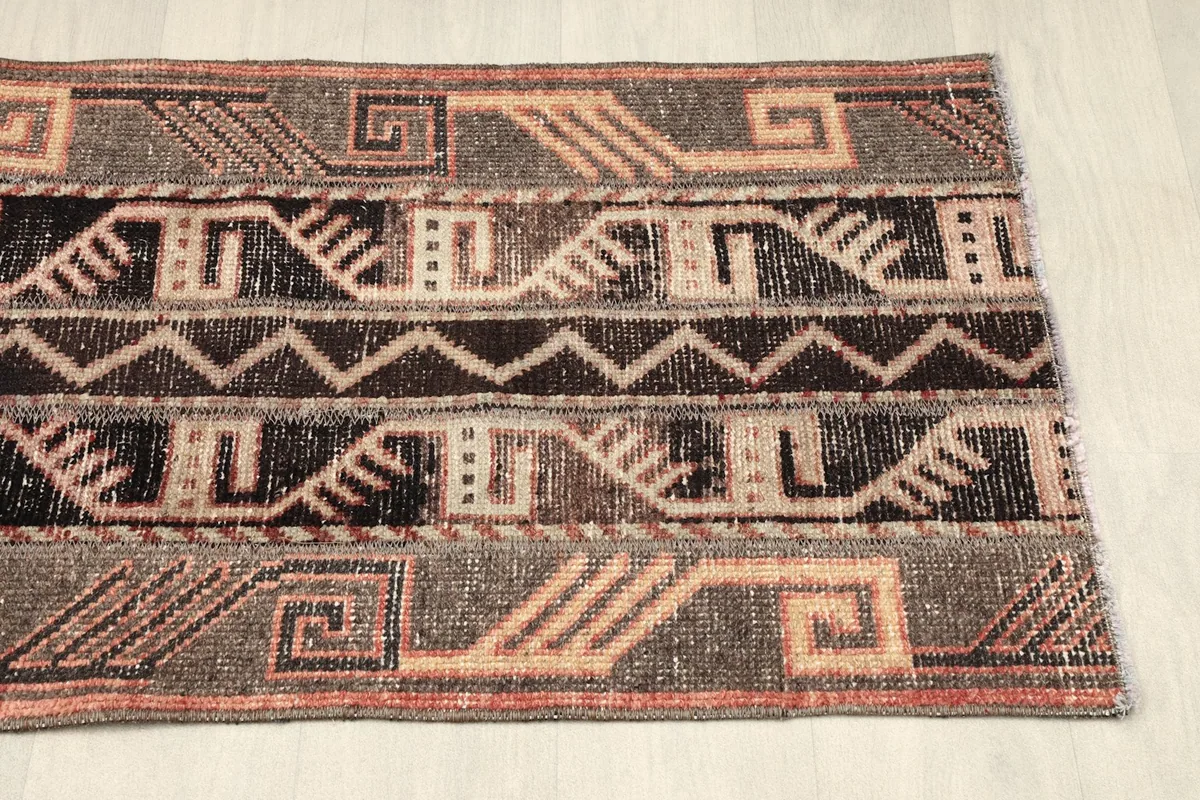 View of the other end of the rug, displaying the consistent geometric pattern and color palette.